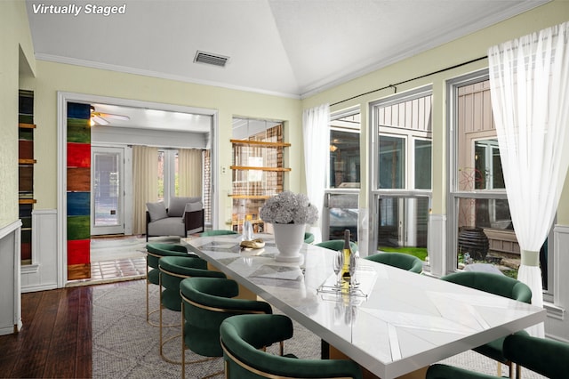 dining space with crown molding, dark wood-type flooring, and vaulted ceiling