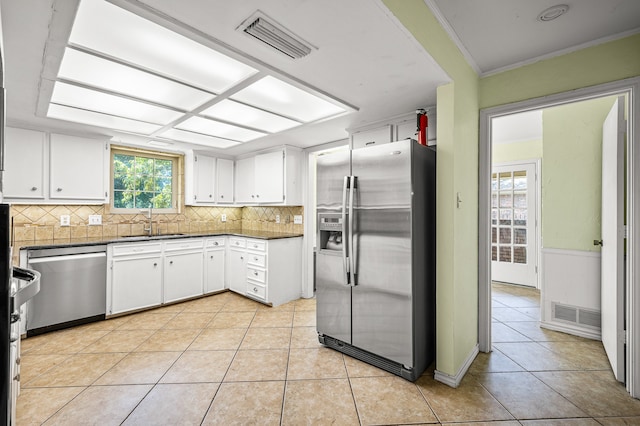 kitchen featuring light tile patterned flooring, stainless steel appliances, sink, and white cabinets