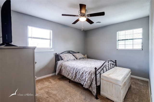 bedroom with multiple windows, carpet floors, and ceiling fan