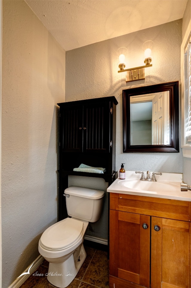 bathroom with vanity, toilet, tile patterned floors, and a textured ceiling