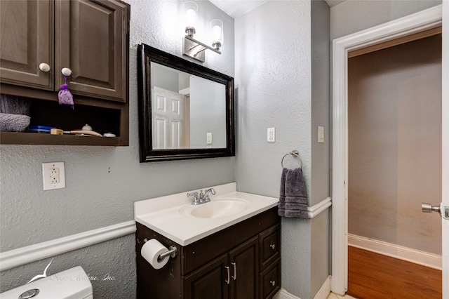 bathroom featuring vanity, toilet, and hardwood / wood-style floors