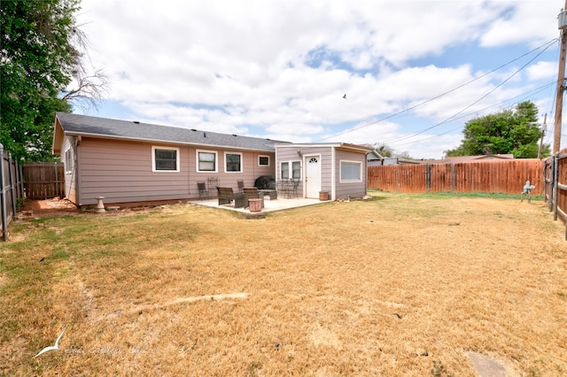 back of property with a patio and a yard