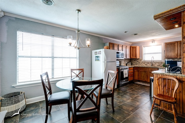 tiled dining area with a notable chandelier, ornamental molding, and a wealth of natural light