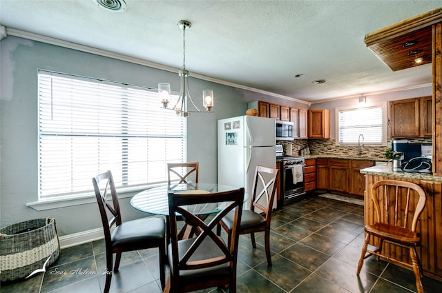 tiled dining space featuring sink, ornamental molding, a chandelier, and plenty of natural light