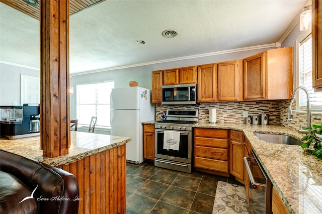 kitchen featuring stainless steel appliances, dark tile patterned floors, sink, light stone countertops, and backsplash