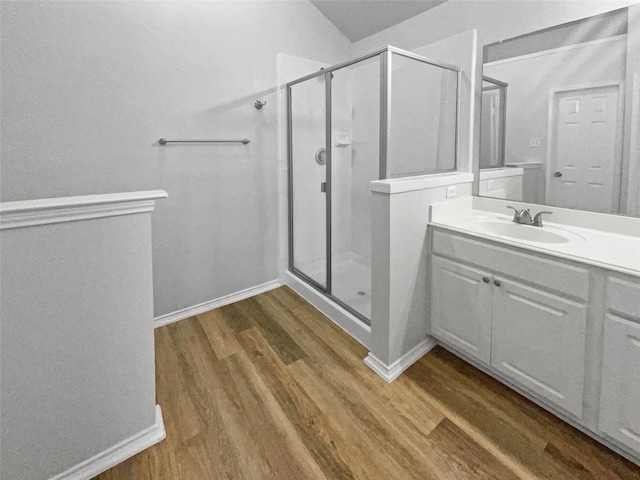 bathroom with hardwood / wood-style flooring, vanity, and a shower with door