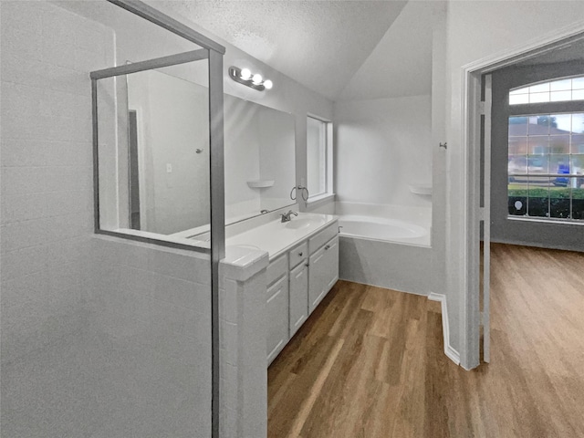 bathroom with lofted ceiling, independent shower and bath, vanity, a textured ceiling, and hardwood / wood-style flooring