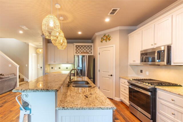 kitchen featuring a kitchen island with sink, hardwood / wood-style floors, and appliances with stainless steel finishes