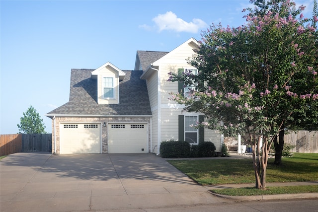 view of front of house with a garage and a front lawn