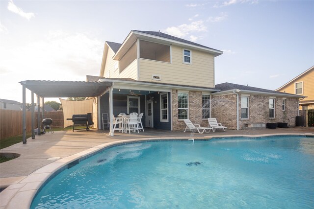 rear view of house with a patio and a fenced in pool