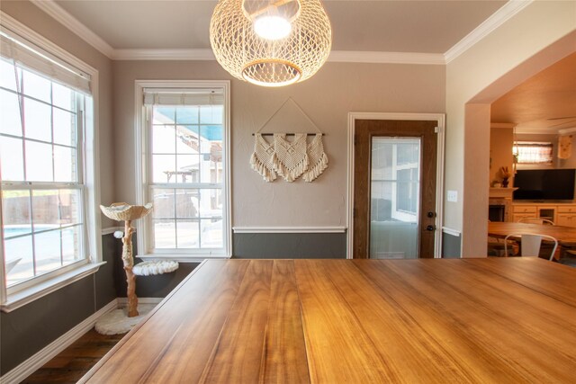 dining room featuring plenty of natural light, crown molding, and hardwood / wood-style flooring