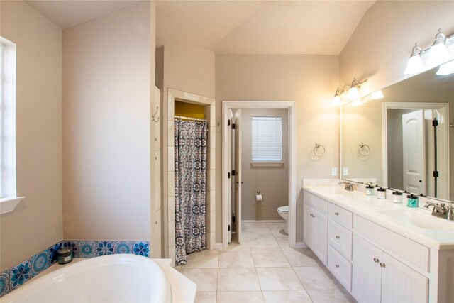 bathroom with tile patterned flooring, dual bowl vanity, a tub to relax in, and toilet