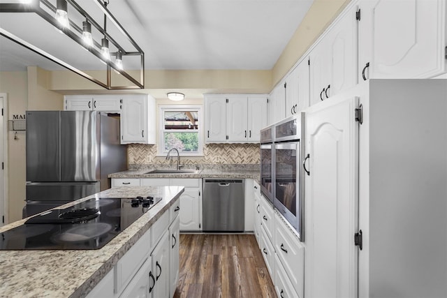 kitchen featuring white cabinetry, dark hardwood / wood-style flooring, decorative backsplash, sink, and appliances with stainless steel finishes