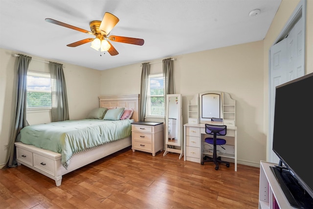 bedroom with hardwood / wood-style flooring, multiple windows, and ceiling fan