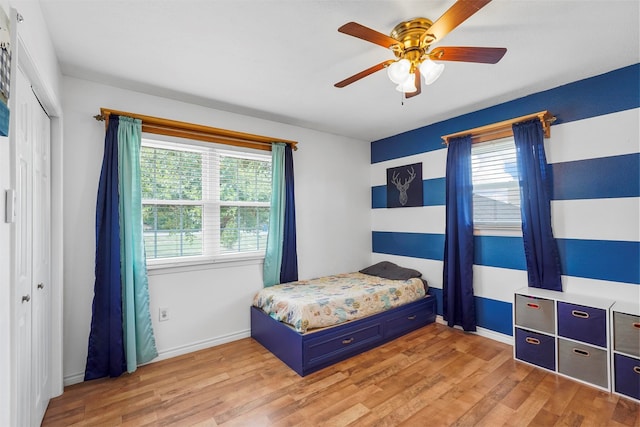 bedroom featuring light wood-type flooring, ceiling fan, and a closet