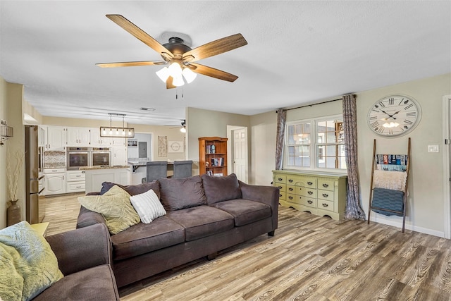 living room featuring light wood-type flooring and ceiling fan