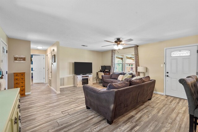 living room with light hardwood / wood-style flooring and ceiling fan