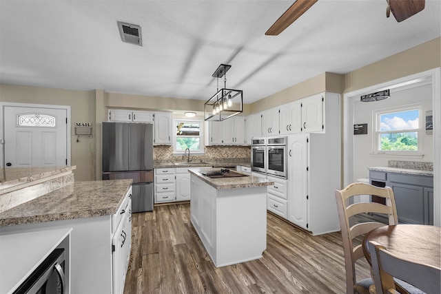 kitchen featuring white cabinetry, a center island, dark hardwood / wood-style floors, and appliances with stainless steel finishes