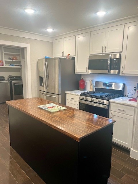 kitchen featuring stainless steel appliances, white cabinets, dark hardwood / wood-style flooring, and separate washer and dryer