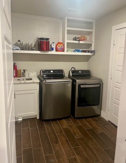 washroom with sink, cabinets, dark wood-type flooring, and washer and clothes dryer