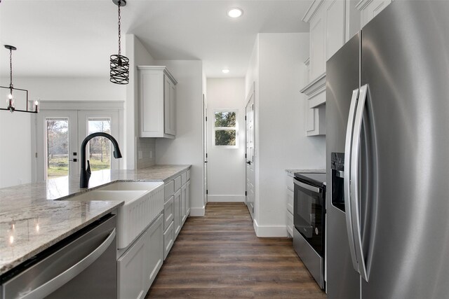 kitchen with a chandelier, decorative light fixtures, stainless steel appliances, and white cabinets