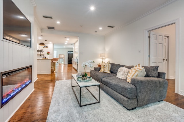 living room featuring ornamental molding and hardwood / wood-style floors