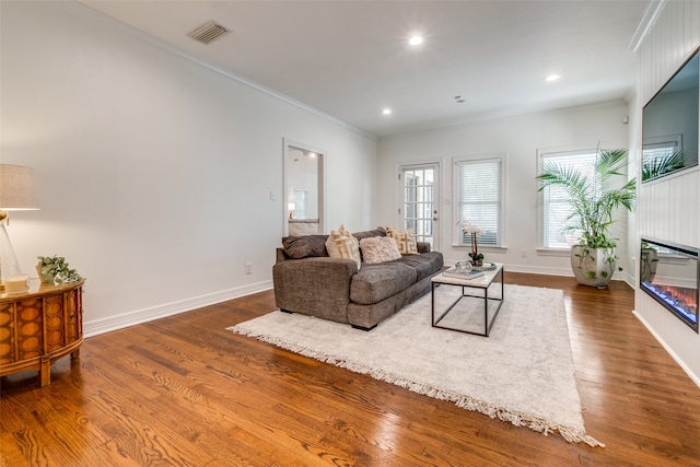 living room with ornamental molding and dark wood-type flooring