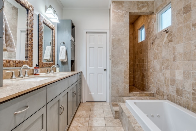 bathroom featuring tile patterned flooring, crown molding, tiled tub, vanity, and tile walls