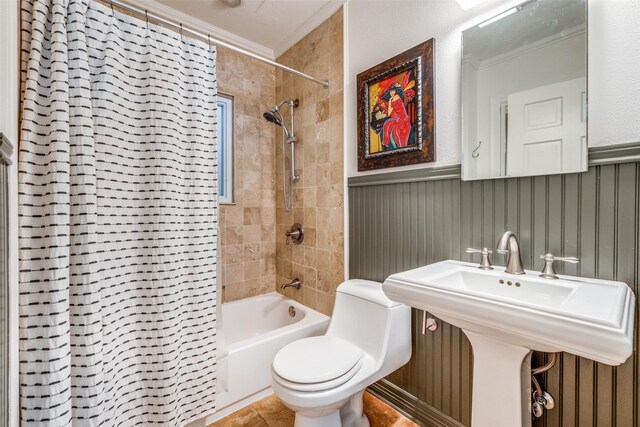 full bathroom featuring sink, tile patterned flooring, shower / bath combo, crown molding, and toilet