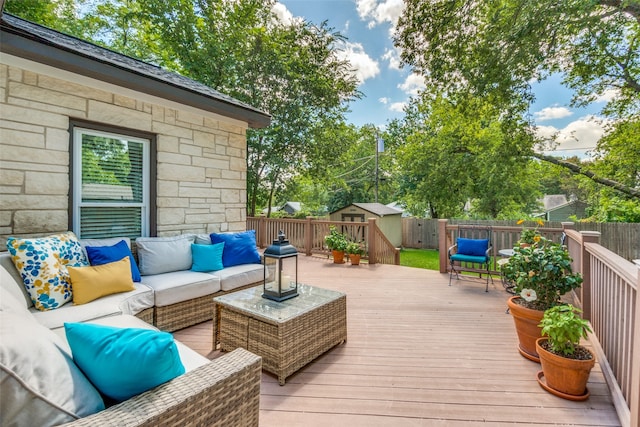 wooden deck featuring a storage shed and outdoor lounge area