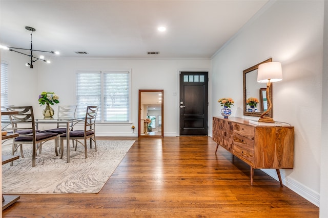 dining space featuring ornamental molding, an inviting chandelier, and hardwood / wood-style flooring