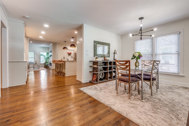 dining space with a chandelier, light hardwood / wood-style flooring, and ornamental molding