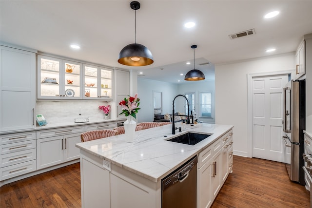 kitchen featuring white cabinetry, dark wood-type flooring, stainless steel appliances, and an island with sink