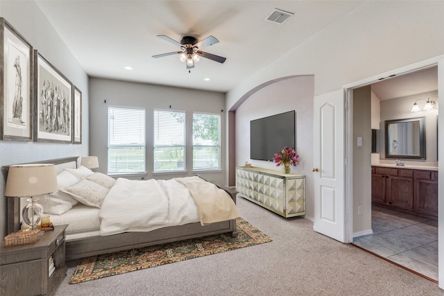 carpeted bedroom featuring ceiling fan, sink, and ensuite bath