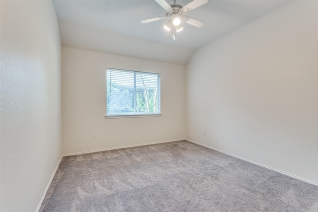 spare room featuring ceiling fan, light colored carpet, and vaulted ceiling