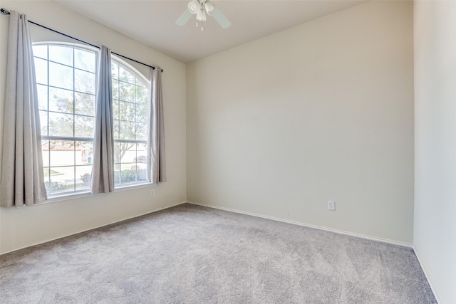 carpeted spare room with ceiling fan