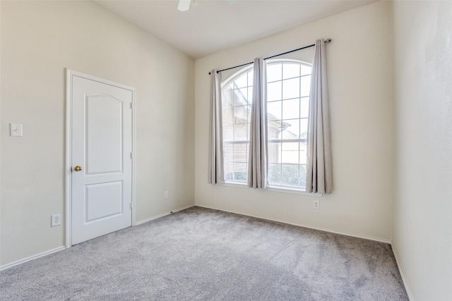 empty room featuring light colored carpet and ceiling fan