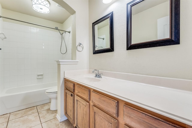 full bathroom featuring tiled shower / bath, vanity, toilet, and tile patterned flooring