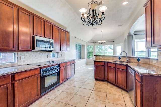 kitchen featuring sink, an inviting chandelier, light stone counters, decorative light fixtures, and black appliances