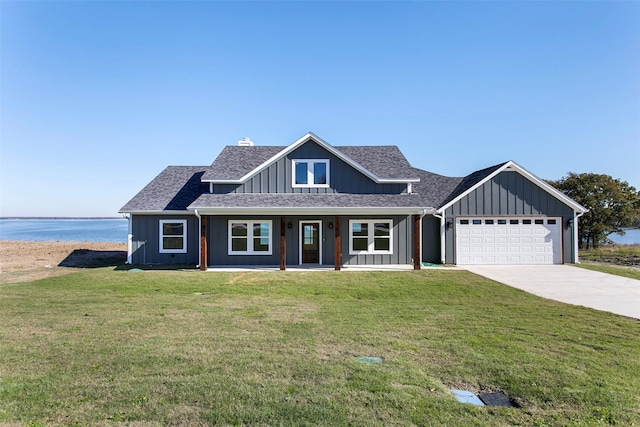 view of front of house featuring a garage, a front yard, and a water view