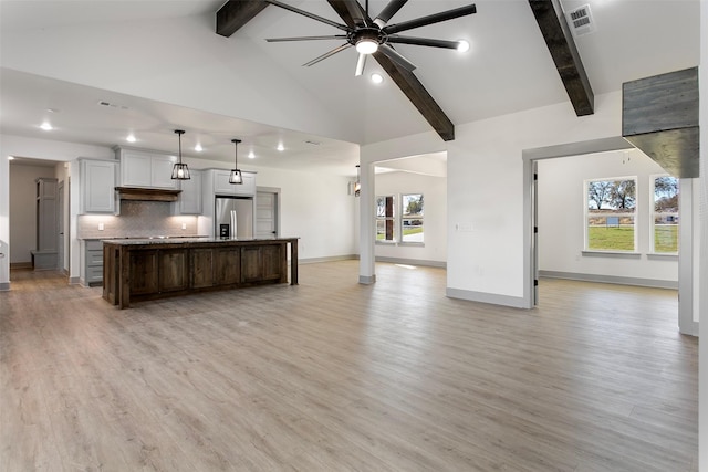 kitchen featuring light hardwood / wood-style floors, plenty of natural light, a kitchen island, and stainless steel fridge with ice dispenser