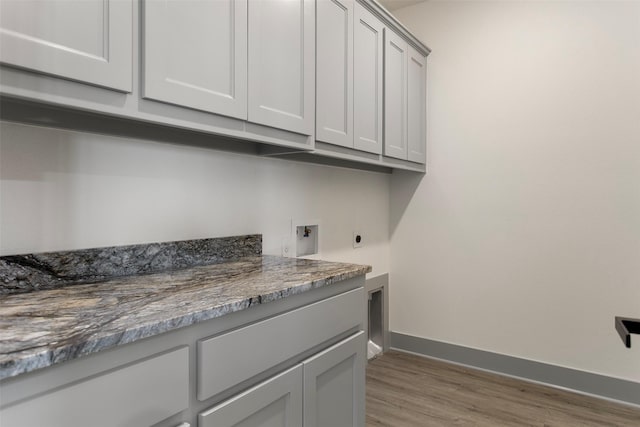 laundry room with cabinets, washer hookup, light hardwood / wood-style floors, and electric dryer hookup