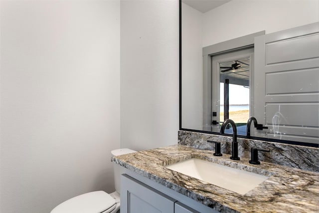 bathroom featuring ceiling fan, vanity, and toilet