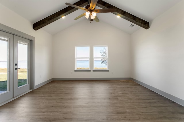 empty room featuring beam ceiling, ceiling fan, plenty of natural light, and dark wood-type flooring