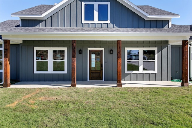 view of exterior entry featuring a porch and a yard