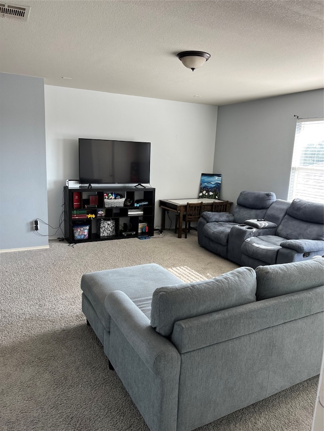 carpeted living room featuring a textured ceiling