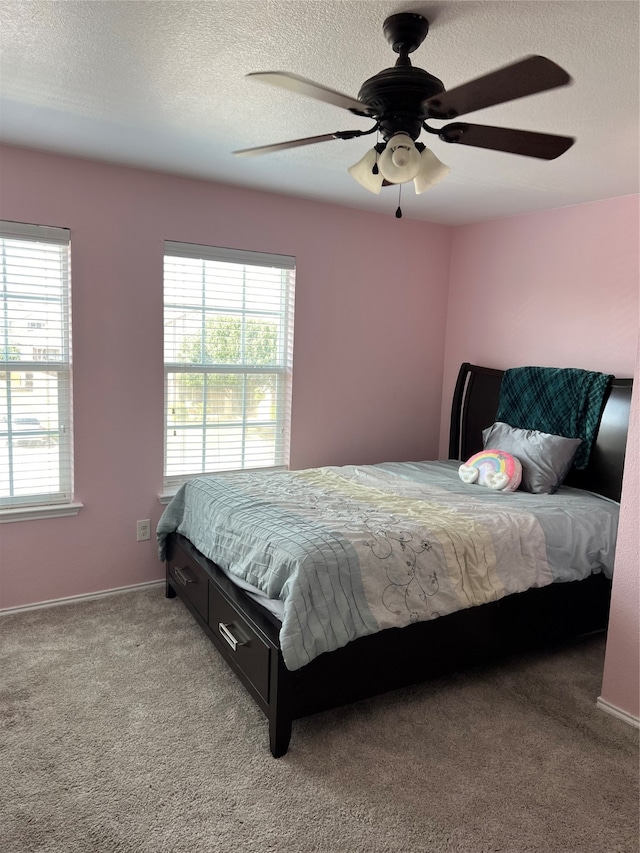 carpeted bedroom with a textured ceiling and ceiling fan