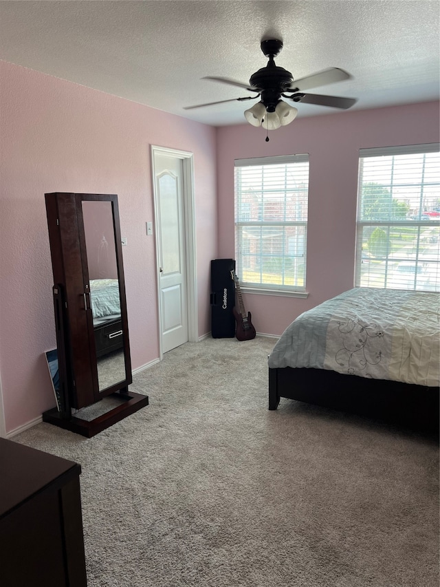 carpeted bedroom with a textured ceiling and ceiling fan