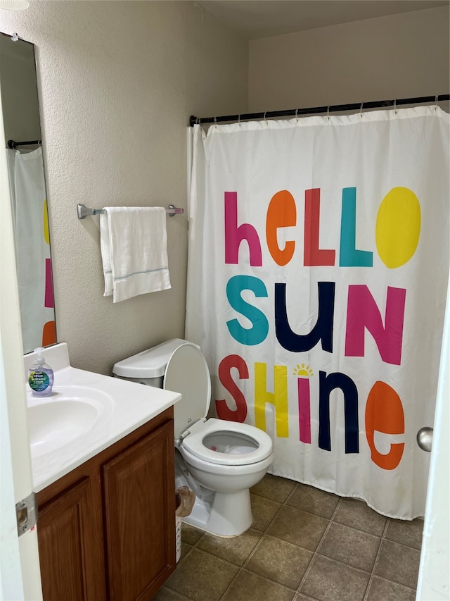 bathroom featuring vanity, tile patterned flooring, and toilet