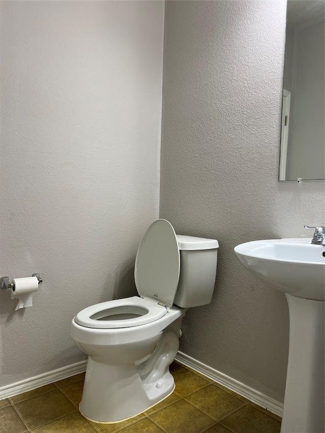 bathroom featuring toilet and tile patterned flooring